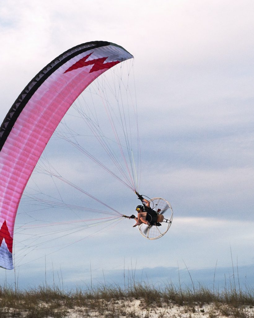 man-paragliding-over-beach-against-sky-1.jpg